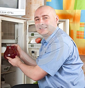 Man putting jug into refrigerator