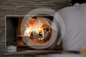 Man Putting Lahmacun Dough in to Hot Stone Oven With Wooden Pizza Peel