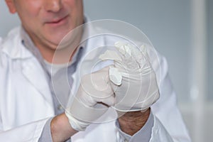 Man putting on latex glove