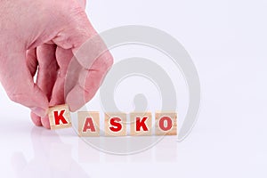 Man putting the letter k on the table, the word 'kasko' on wooden blocks