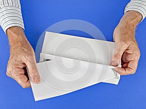 Man putting letter into white envelope