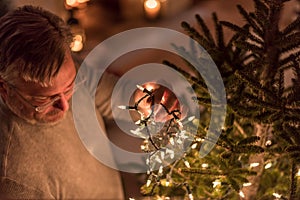 Man putting lights on the Christmas tree