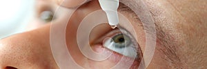 Man putting liquid drops in his eye solving vision problem