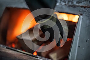 Man putting log onto wood burning stove