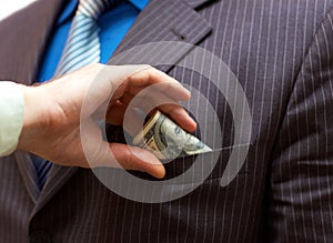 Man putting money into suit pocket photo