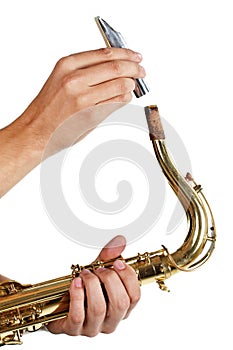 Man putting the mouthpiece back on the saxophone photo