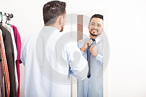 Man putting on necktie in a dressing room