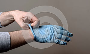 Man putting on a pair of latex gloves