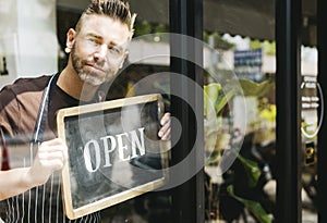 Man putting on shop open sign