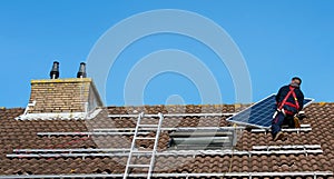 Man putting the solar panel on the roof