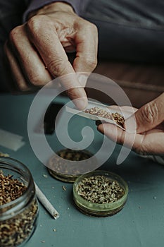 man putting some tobacco on a rolling paper