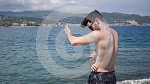 Man Putting on Sunscreen Cream, at Beach