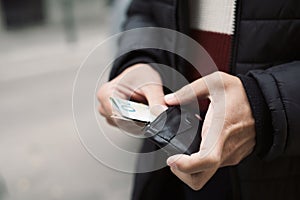 Man putting in or taking off money from a wallet