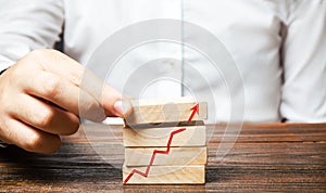 A man is putting together blocks with a red arrow chart. Build a business and increase profits, achieve success. Strategy