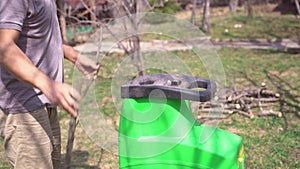 Man putting tree branches into garden shredder