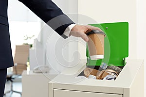 Man putting used paper cup into trash bin, closeup. Waste recycling