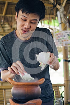 Man putting vegetable in Chim chum pot