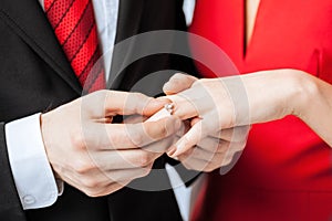 Man putting wedding ring on woman hand