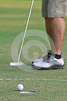 A man putts a golf ball photo