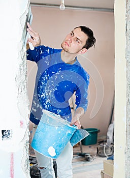 Man puttying doorway in apartment