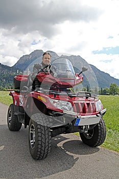 A man on quad before the mountains in Bavaria