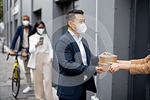 Man in queuq taking food order from woman