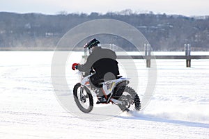 Man racing dirt bike on frozen pond