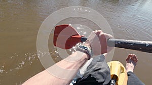 Man on raft paddles in river. Clip. First-person view of quiet muddy river rafting in spring. Quiet single river rafting