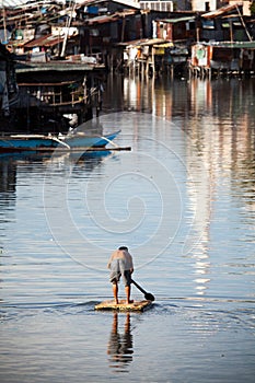 Man on raft - squatter shanty area photo