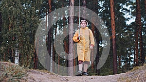 A man in a raincoat walks out of the forest and going on fishing