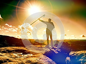 Man raised arm with trekking stick. Tourist hiking mountain trail