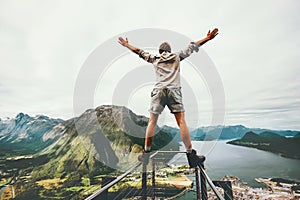 Man raised hands balancing at the edge cliff