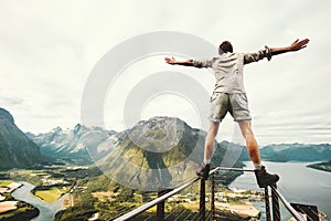 Man raised hands balancing at the edge in Norway