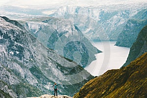 Man raised hands traveling at Naeroyfjord mountains