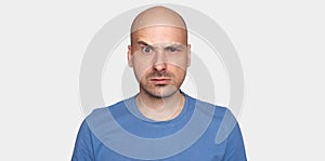 Man raised his eyebrow. Angry bald guy isolated