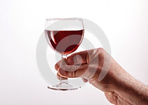 A man raises a glass goblet with red wine. Isolated on a white
