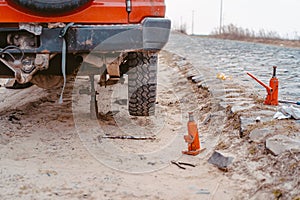 A man raises on a jack 4x4 off road truck