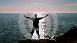 Man raising arms in front of the sea