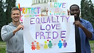 Man raising Equality love pride poster together with LGBT activists, pride march