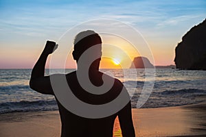 Man Raising Fist on Sand with Copy Space