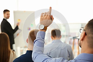 Man raising hand to ask question at business training, closeup