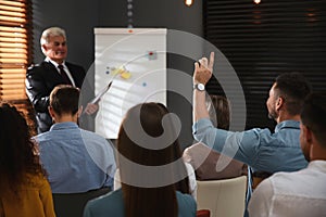 Man raising hand to ask question at seminar