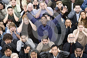 Man Raising Hands While People Covering Their Ears