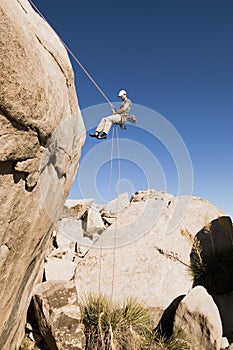 Man Rappelling From Cliff