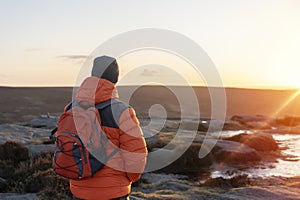 Man reaching the destination and on the top of mountain at sunrise or sunset on cold day Travel Lifestyle concept The