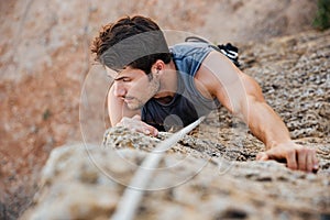 Man reaching for a grip while he rock climbs