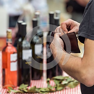 Man reaching for his wallet at the street bar in order to pay for the bottles of wine