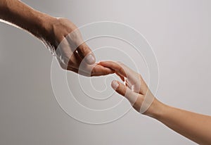 Man reaching for woman`s hand on grey background, closeup.