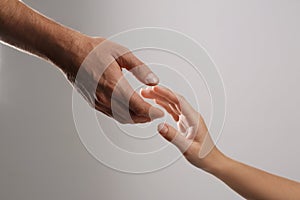 Man reaching for woman`s hand on grey background, closeup.