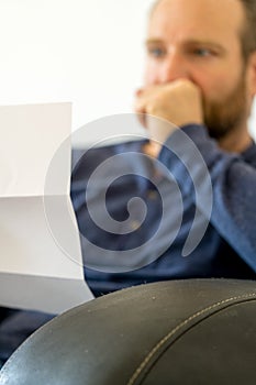 Man reacting to bad news he receives in a letter selective focus